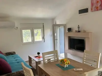 a living room with a blue couch and a table at Apartmani Lucija Sutomore in Sutomore