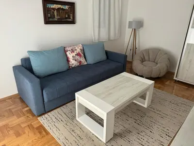 a living room with a blue couch and a coffee table at The View Apartment in Budva