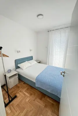 a bedroom with a bed and a wooden floor at The View Apartment in Budva