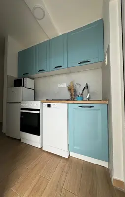 a kitchen with blue cabinets and white appliances at The View Apartment in Budva