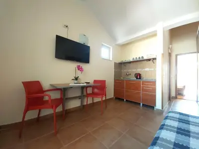 a room with a table and chairs and a kitchen at Apartments Premier in Budva