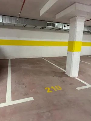 an empty parking garage with yellow markings on the floor at Apartment 43 with Garage in Podgorica