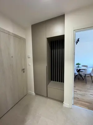 a room with a door and a dining room with a table at Apartment 43 with Garage in Podgorica