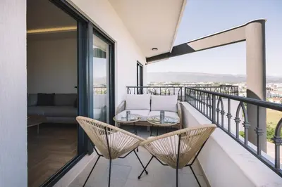 a balcony with a table and chairs and a couch at Azanti Residence in Ulcinj