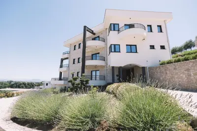 a building on top of a hill with plants at Azanti Residence in Ulcinj