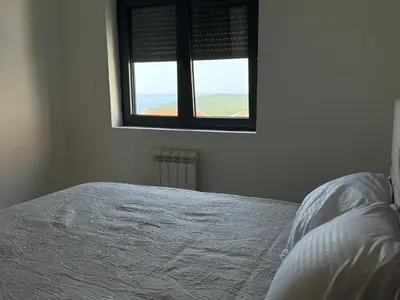 a bedroom with a white bed with a window at Alice in Seoca