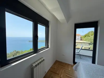 a room with two windows and a view of the ocean at Alice in Seoca
