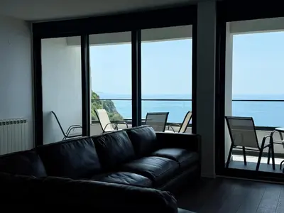 a black leather couch in a room with a balcony at Alice in Seoca