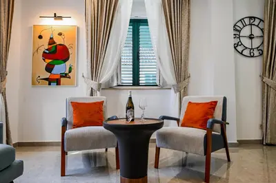 a living room with two chairs and a table with a bottle of wine at Old Town Lux in Kotor