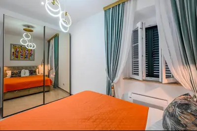 a bedroom with an orange bed and a mirror at Old Town Lux in Kotor