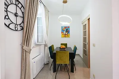 a dining room with a table and chairs and a clock at Old Town Lux in Kotor