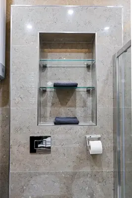 a bathroom with glass shelves and towels on a wall at Old Town Lux in Kotor