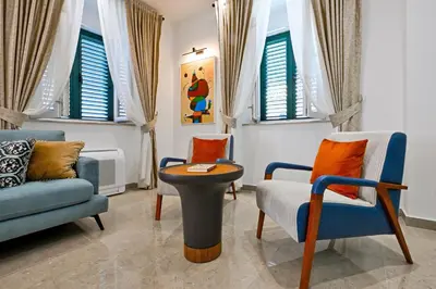 a living room with chairs and a table and windows at Old Town Lux in Kotor