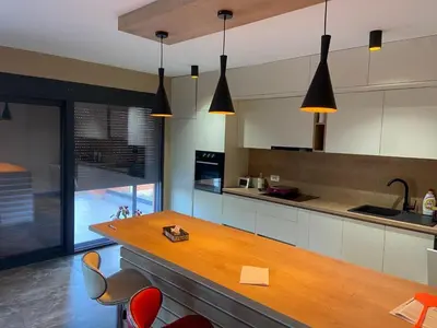 a kitchen with a wooden counter and some chairs at Vila Enesa in Dobra Voda