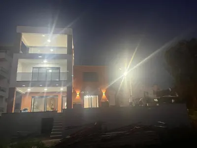 a building with the sun shining on it at night at Vila Enesa in Dobra Voda