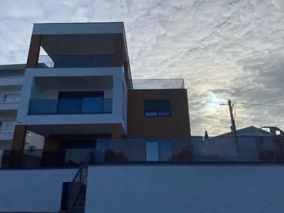 a building with a cloudy sky in the background at Vila Enesa in Dobra Voda