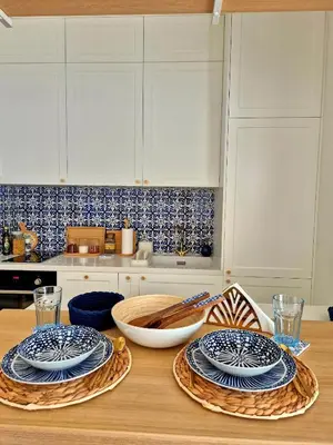 a kitchen with a wooden table with plates on it at Sea Colours Apartment Budva in Budva