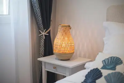 a vase sitting on a table next to a bed at Sea Colours Apartment Budva in Budva