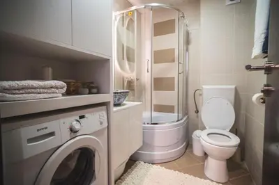 a bathroom with a toilet and a washing machine at Sea Colours Apartment Budva in Budva