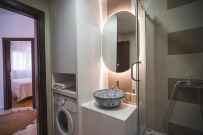 a bathroom with a sink and a washing machine at Sea Colours Apartment Budva in Budva