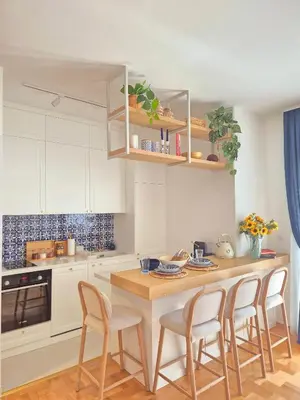 a kitchen with white cabinets and a table with chairs at Sea Colours Apartment Budva in Budva