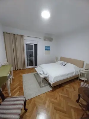 a bedroom with a bed and a table and a desk at Jon in Ulcinj