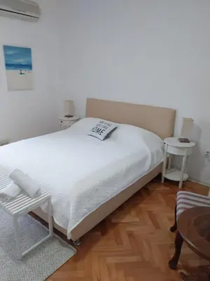 a bedroom with a white bed and a chair at Jon in Ulcinj