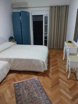 a bedroom with two beds and a wooden floor at Jon in Ulcinj