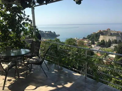 a balcony with a table and chairs and the ocean at Apartment Luna in Ulcinj