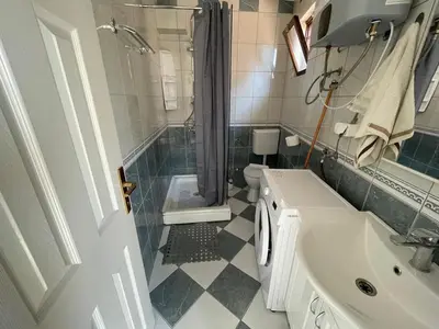 a bathroom with a sink and a shower and a toilet at Apartment Luna in Ulcinj