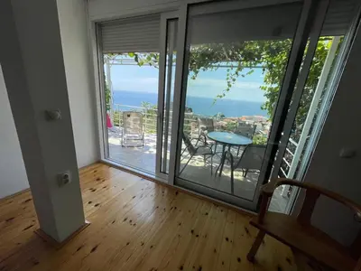 a room with a balcony with a view of the ocean at Apartment Luna in Ulcinj