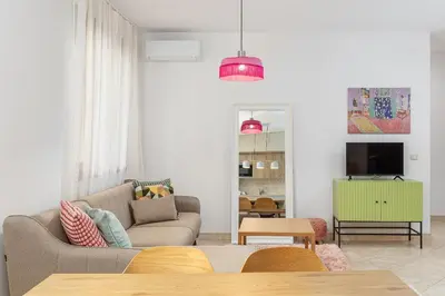 a living room with a couch and a tv at Just 7 Min from the Beach Stylish 2BR in Becici