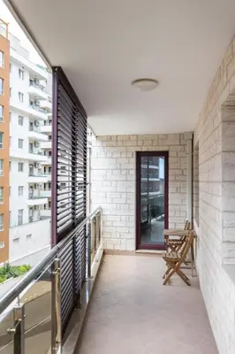 a balcony with a bench and a window at Just 7 Min from the Beach Stylish 2BR in Becici
