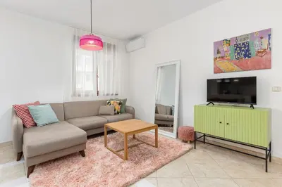 a living room with a couch and a tv at Just 7 Min from the Beach Stylish 2BR in Becici