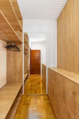 a hallway with wood paneled walls and wooden shelves at Just 7 Min from the Beach Stylish 2BR in Becici