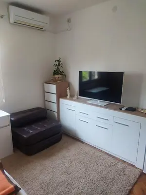 a living room with a flat screen tv and a ottoman at Goran in Budva