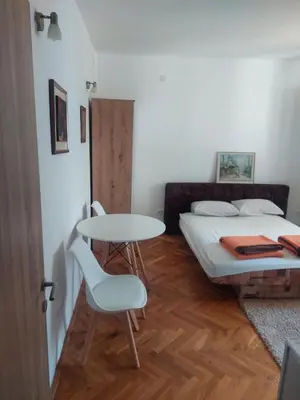 a small room with a bed and a table and chair at Goran in Budva