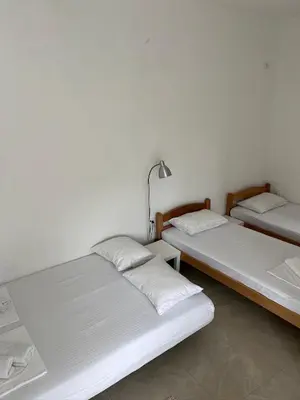 two beds in a room with white walls at Apartmani Aleksandar Rudinac Čanj in Čanj