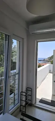 a room with two chairs and a large window at Apartmani Aleksandar Rudinac Čanj in Čanj