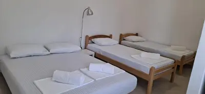a room with three beds and a lamp at Apartmani Aleksandar Rudinac Čanj in Čanj