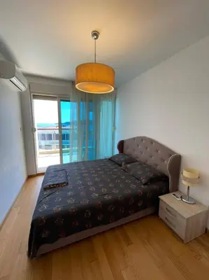 a bedroom with a bed and a large window at Apartment WaveSea in Becici