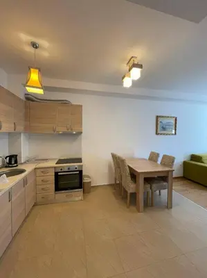 a kitchen with a wooden table and a dining room at Apartment WaveSea in Becici