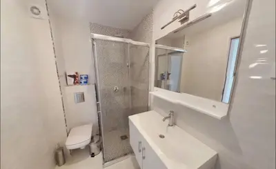 a white bathroom with a sink and a shower at Apartment WaveSea in Becici