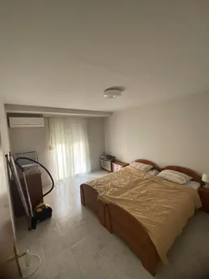 a bedroom with a large bed and a vacuum at Kosta in Bar