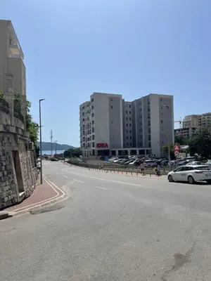 an empty street with cars parked in a parking lot at Lux apartment Ruzmarin in Becici