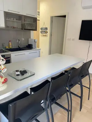 a kitchen with a table and chairs in a kitchen at Lux apartment Ruzmarin in Becici