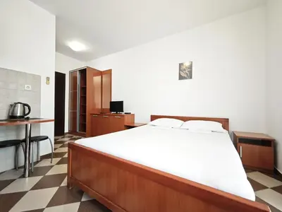 a bedroom with a large bed and a kitchen at Guest House Anika in Becici