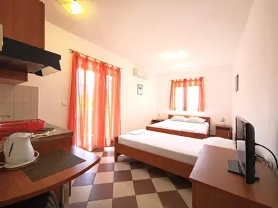 a hotel room with two beds and a kitchen at Guest House Anika in Becici