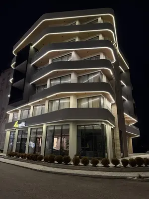 a tall white building with a lot of windows at Hotel Adler in Ulcinj