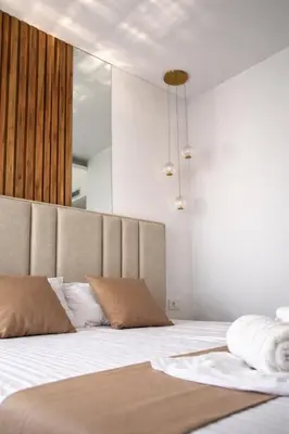 a bedroom with a bed with white sheets and brown pillows at Hotel Adler in Ulcinj